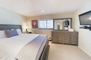 Master bedroom features a King size bed and a wall mounted smart TV