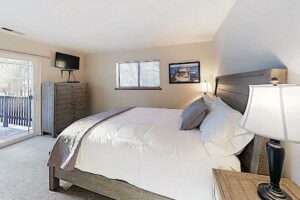 Master Bedroom with Queen bed, built in TV, and deck access